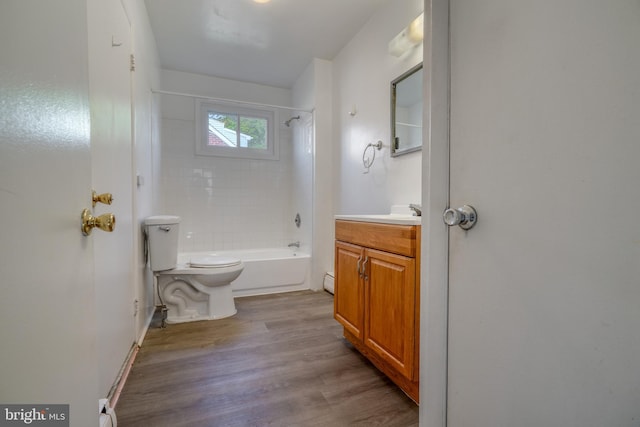 full bathroom with tiled shower / bath, vanity, hardwood / wood-style flooring, and toilet