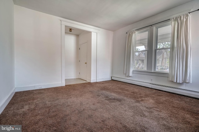 carpeted spare room featuring baseboard heating