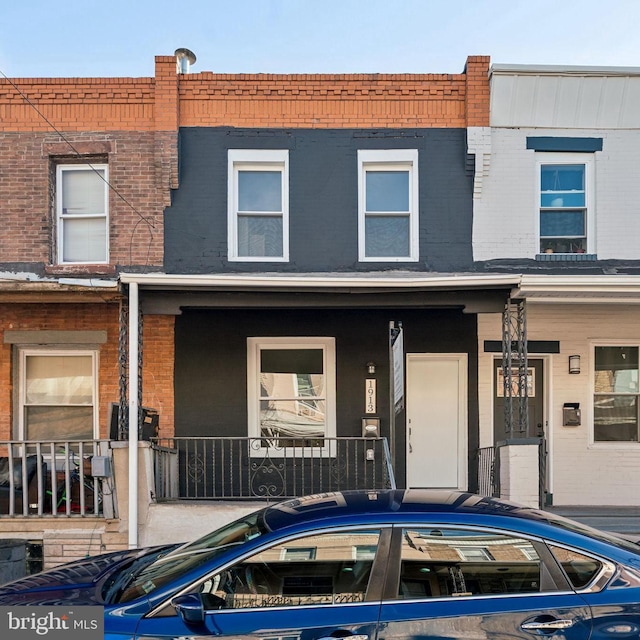 townhome / multi-family property featuring covered porch