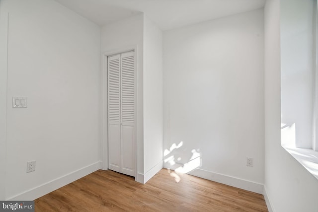 unfurnished bedroom with a closet and light hardwood / wood-style floors