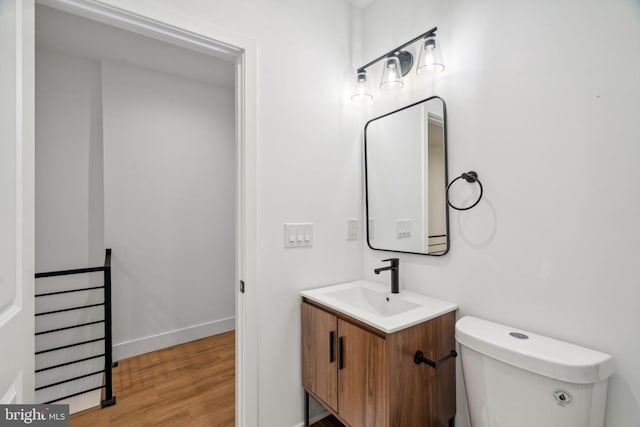 bathroom featuring vanity, hardwood / wood-style flooring, and toilet