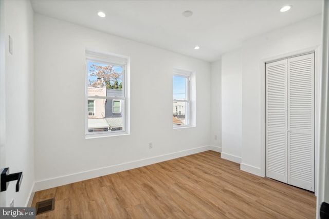 unfurnished bedroom with light hardwood / wood-style flooring and a closet