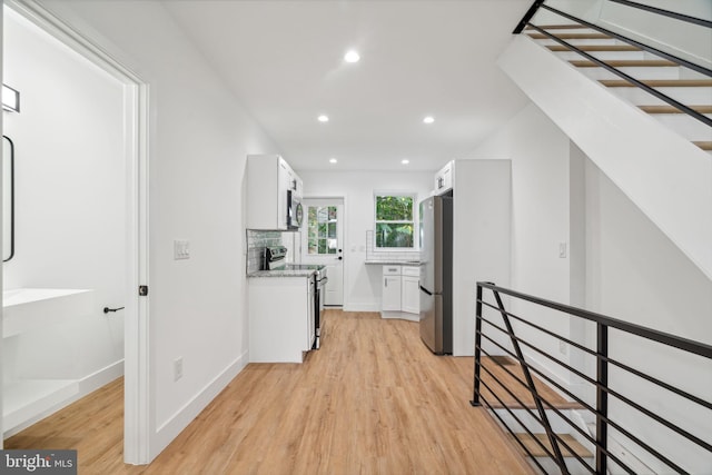 corridor with light hardwood / wood-style floors