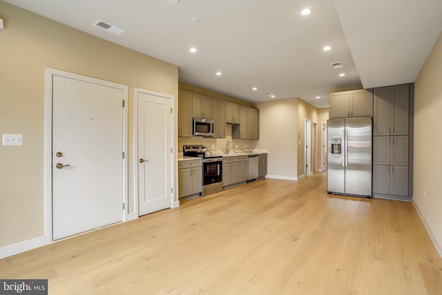 kitchen featuring appliances with stainless steel finishes, light hardwood / wood-style floors, and sink