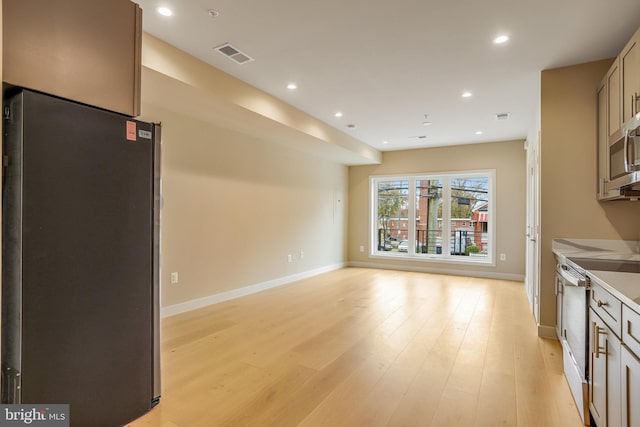 kitchen featuring stainless steel fridge, light hardwood / wood-style flooring, and white electric range