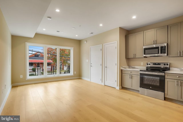 kitchen featuring gray cabinetry, appliances with stainless steel finishes, and light hardwood / wood-style flooring