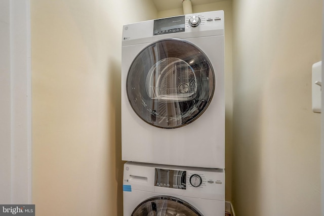 washroom featuring stacked washer / drying machine