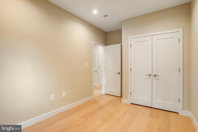 unfurnished bedroom with a closet and light hardwood / wood-style flooring