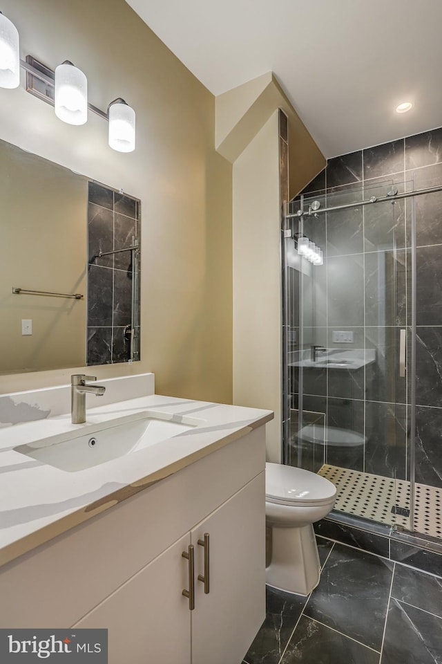 bathroom featuring vanity, toilet, and an enclosed shower