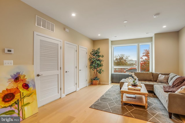 living room featuring radiator and light hardwood / wood-style flooring