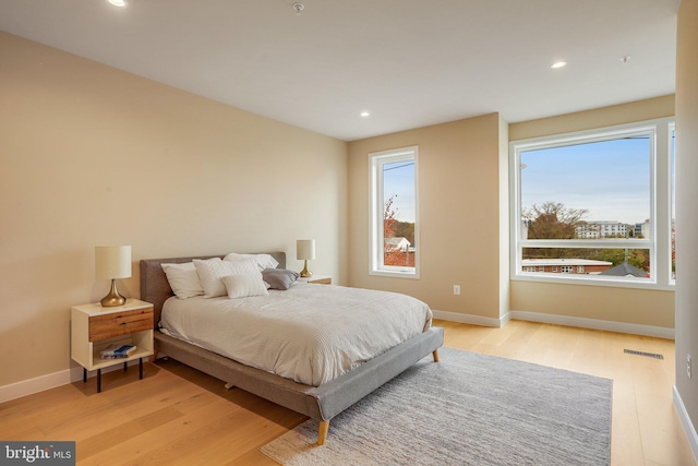 bedroom with light wood-type flooring and multiple windows