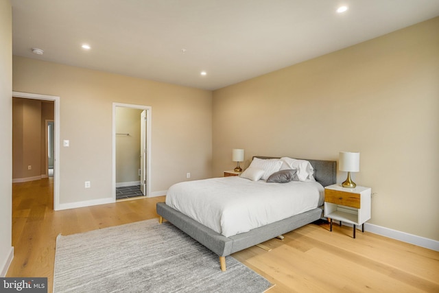 bedroom with light hardwood / wood-style floors and a spacious closet