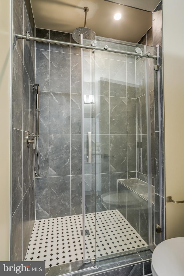 bathroom with tile patterned floors, an enclosed shower, and toilet