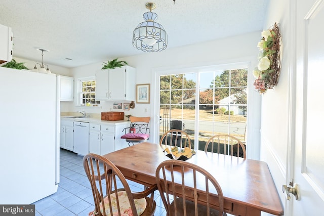 dining space featuring a textured ceiling, sink, and tile patterned floors