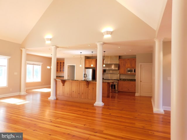 unfurnished living room featuring high vaulted ceiling and light wood-type flooring