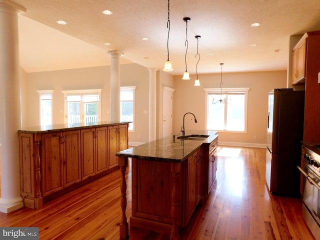 kitchen with appliances with stainless steel finishes, a spacious island, a healthy amount of sunlight, and pendant lighting