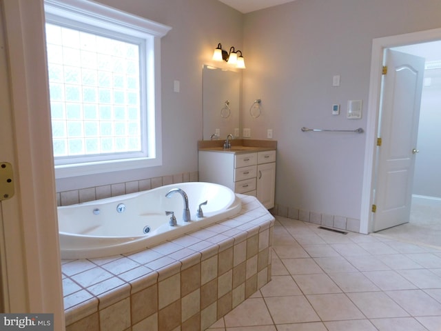 bathroom featuring vanity, tile patterned flooring, tiled tub, and plenty of natural light