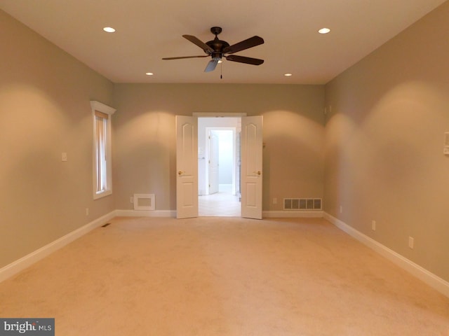 carpeted spare room featuring ceiling fan