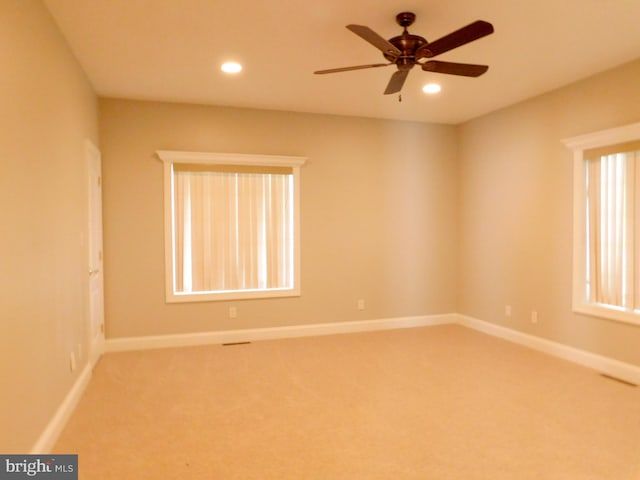 spare room with ceiling fan and carpet