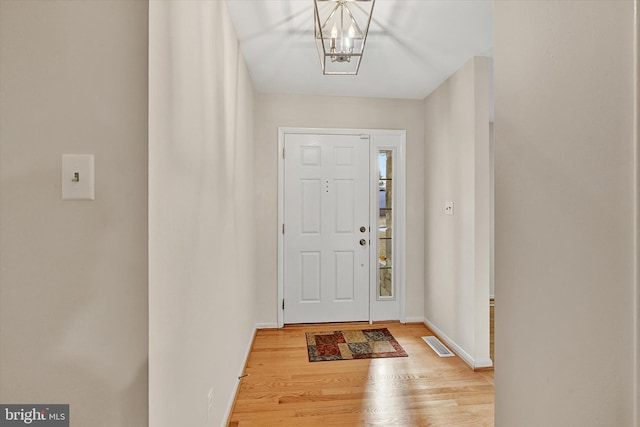 entrance foyer featuring a notable chandelier and light hardwood / wood-style flooring