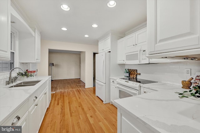 kitchen with light hardwood / wood-style floors, light stone counters, and white cabinetry