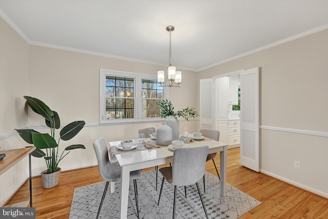 dining space featuring light wood-type flooring, an inviting chandelier, and crown molding