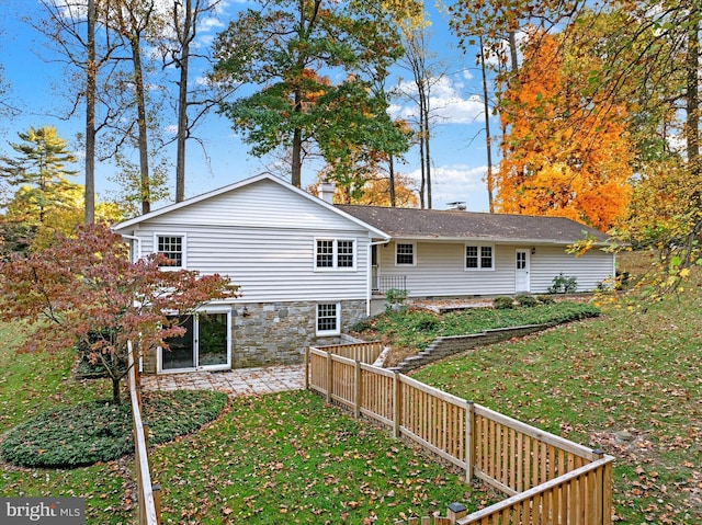 rear view of property featuring a yard