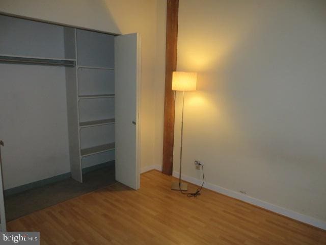 unfurnished bedroom featuring hardwood / wood-style floors and a closet