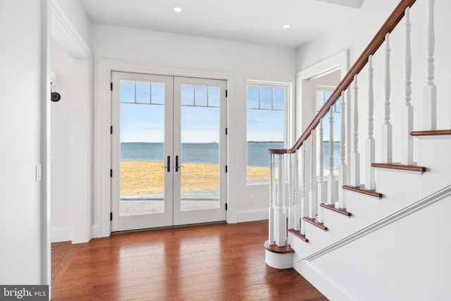 foyer entrance with stairway, wood finished floors, baseboards, recessed lighting, and french doors