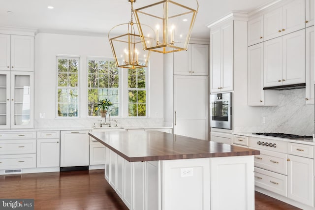 kitchen featuring paneled dishwasher, visible vents, white cabinets, tasteful backsplash, and a center island