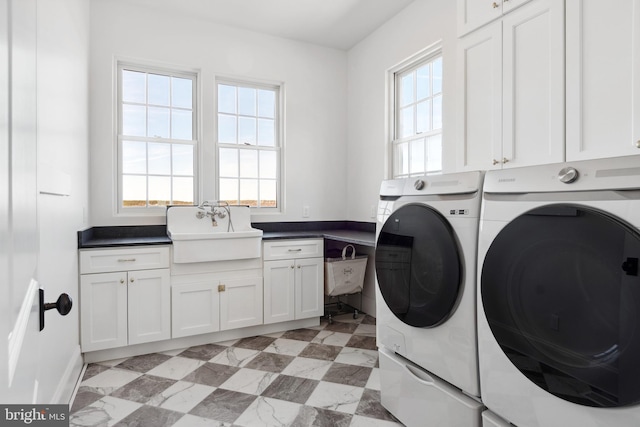 laundry room with a sink, cabinet space, light floors, and washer and clothes dryer