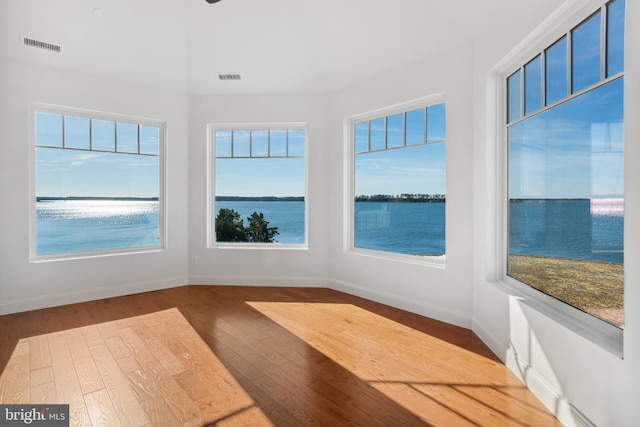 unfurnished sunroom featuring visible vents and a water view