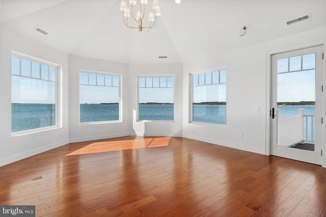 unfurnished sunroom featuring visible vents, plenty of natural light, and lofted ceiling