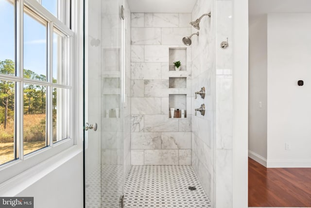 bathroom featuring tiled shower and baseboards