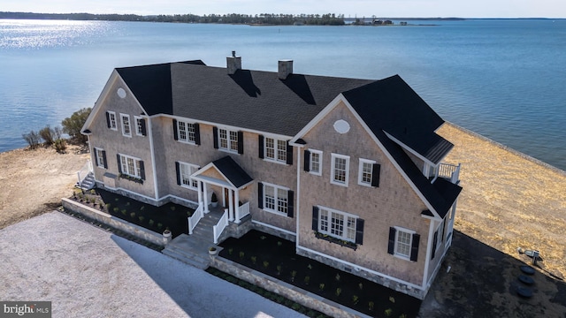 view of front of home featuring a water view and a chimney