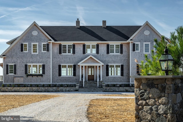 shingle-style home with a shingled roof and a chimney