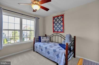 bedroom with ceiling fan and light colored carpet