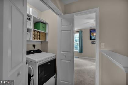 laundry room featuring carpet and washer / dryer