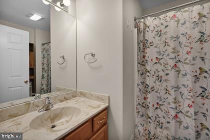 bathroom with a shower with shower curtain and vanity