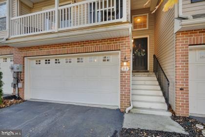 doorway to property with a garage and a balcony