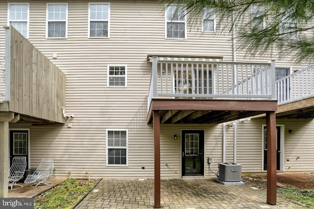 rear view of property with central air condition unit and a patio area