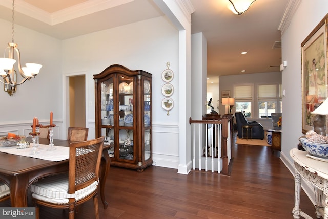 dining space featuring dark hardwood / wood-style flooring, crown molding, and a chandelier