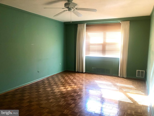 unfurnished room with ornamental molding, parquet flooring, and ceiling fan