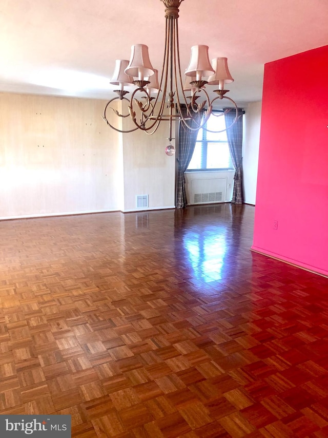 unfurnished dining area with an inviting chandelier and dark parquet flooring