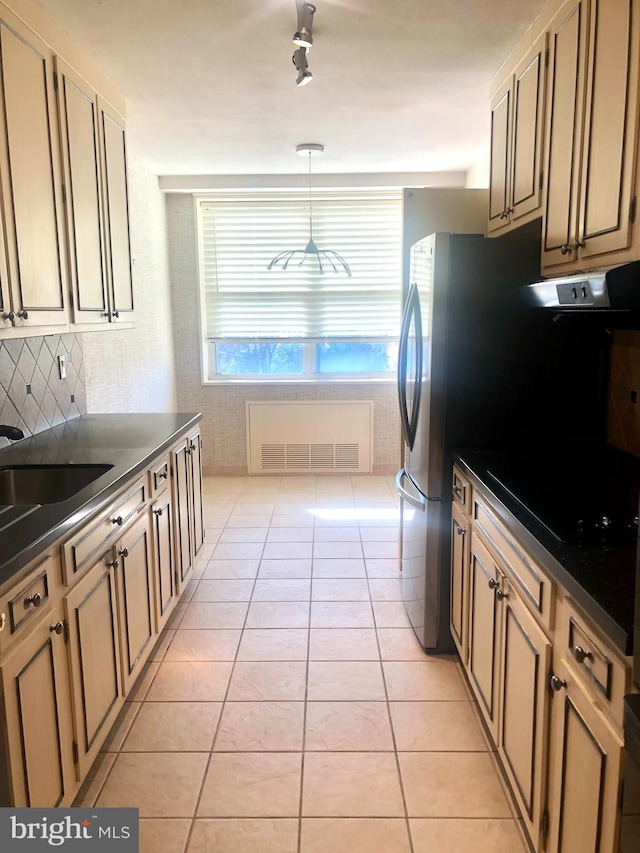 kitchen featuring black electric stovetop, cream cabinets, light tile patterned floors, sink, and decorative light fixtures