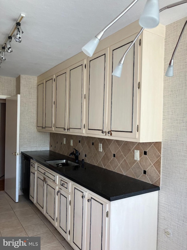 kitchen with dishwasher, backsplash, sink, and light tile patterned floors