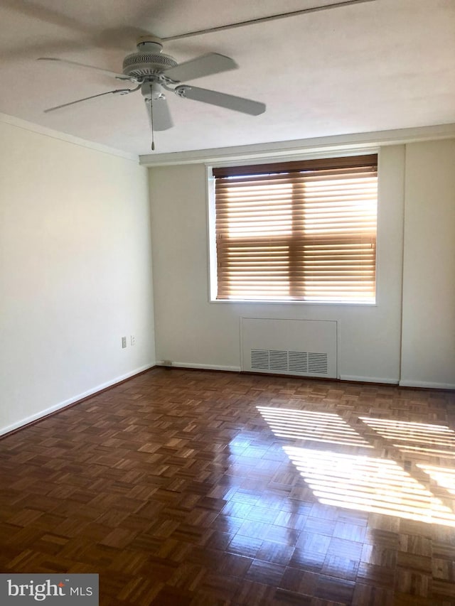 unfurnished room featuring radiator, a wealth of natural light, ceiling fan, and crown molding