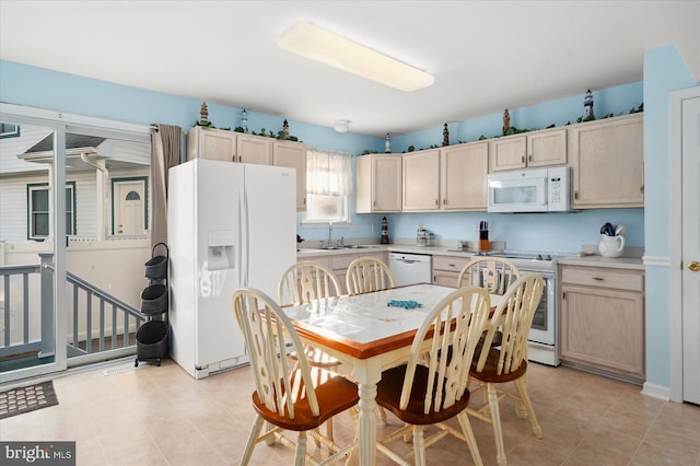 kitchen featuring light brown cabinetry, white appliances, and sink