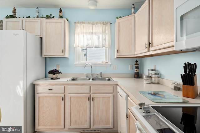 kitchen featuring light brown cabinets, sink, and white appliances