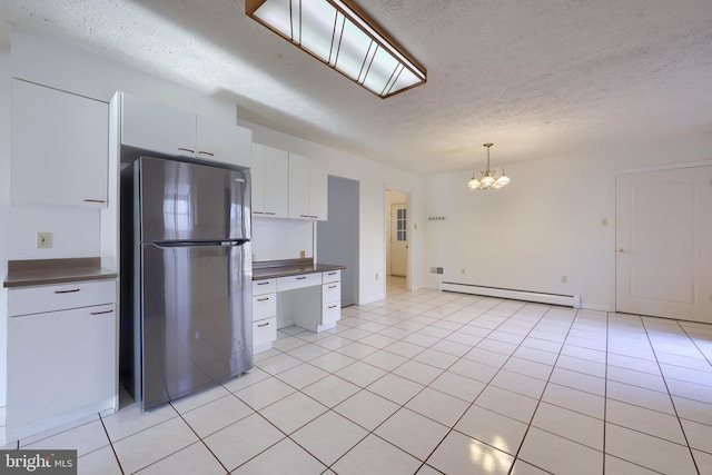 kitchen featuring freestanding refrigerator, a textured ceiling, a chandelier, and baseboard heating